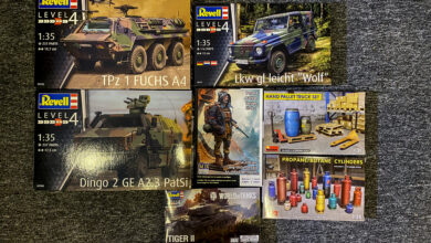 Sammlung von Plastikmodellbausätzen mit militärischen Fahrzeugen und Zubehör.